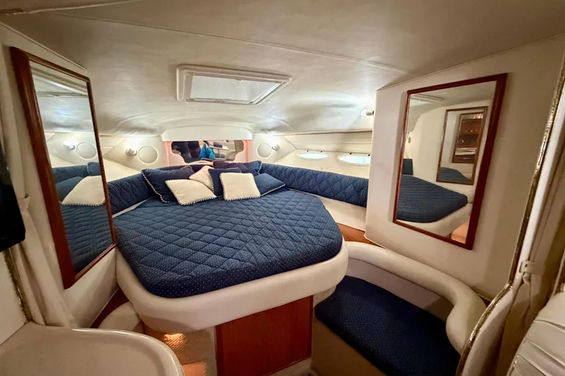 Slide: The Image of Luxurious cabin interior of 2001 Sea Ray 340 Sundancer with blue bedding and mirrors. - 16