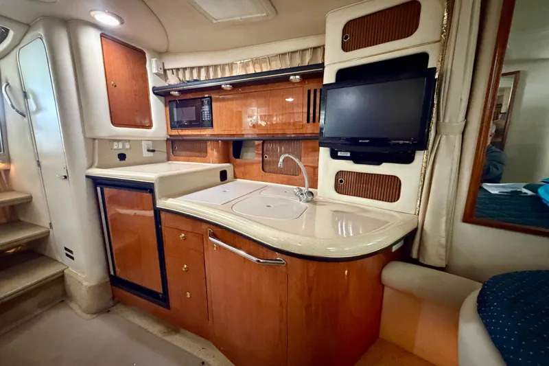 Slide: The Image of 2001 Sea Ray 340 Sundancer interior kitchen with sink, microwave, and TV. - 19