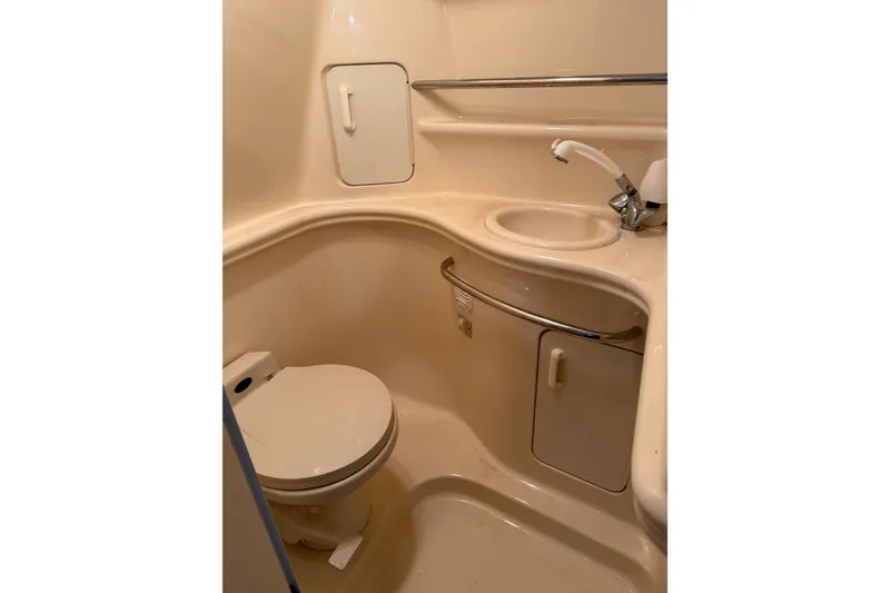 Slide: The Image of 2001 Sea Ray 340 Sundancer bathroom with toilet, sink, and storage cabinet. - 24