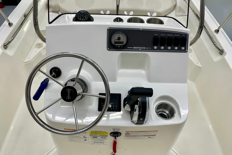 Slide: The Image of Boston Whaler 170 Montauk 2026 helm with steering wheel and controls. - 3
