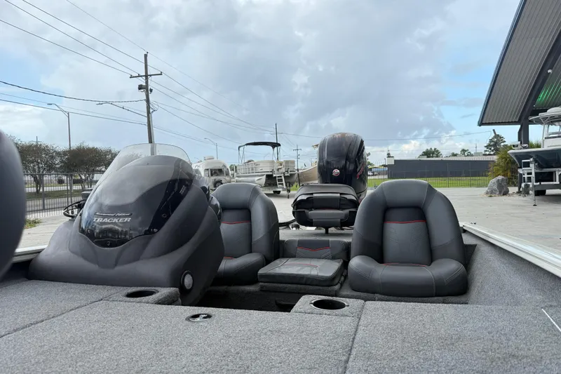 Slide: The Image of 2022 Tracker Pro Team 190 TX Tournament Edition boat with seating and console, parked outdoors. - 13