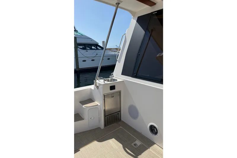 Slide: The Image of 2026 Ranger Tugs R-43 CB boat deck with sink and storage, docked beside another yacht. - 10