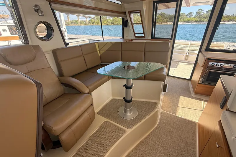 Slide: The Image of Luxurious interior of 2026 Ranger Tugs R-43 CB yacht with leather seating and glass table. - 19