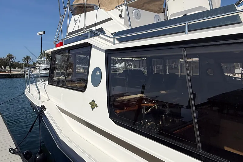 Slide: The Image of 2026 Ranger Tugs R-43 CB yacht docked at marina, showcasing sleek design and spacious cabin. - 2