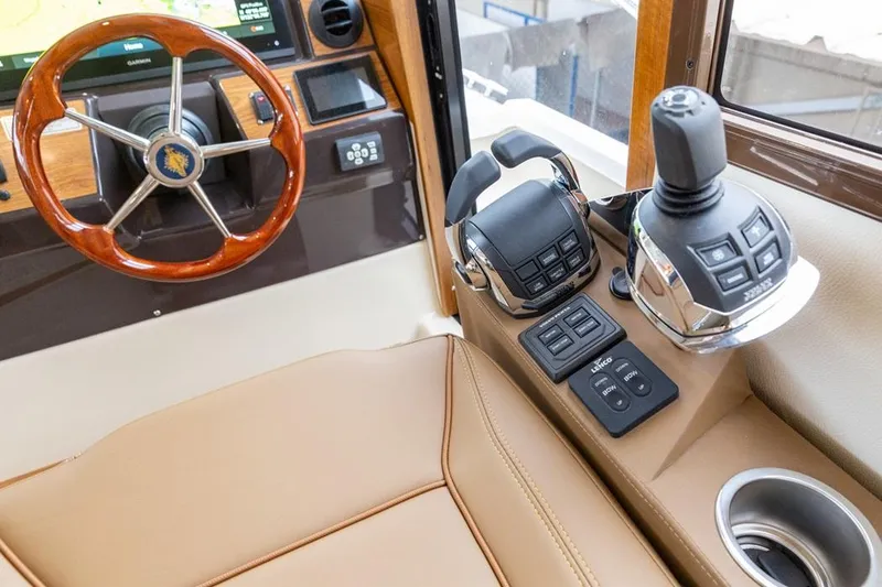 Slide: The Image of 2025 Ranger Tugs 43 Command Bridge helm with joystick controls and wooden steering wheel. - 23