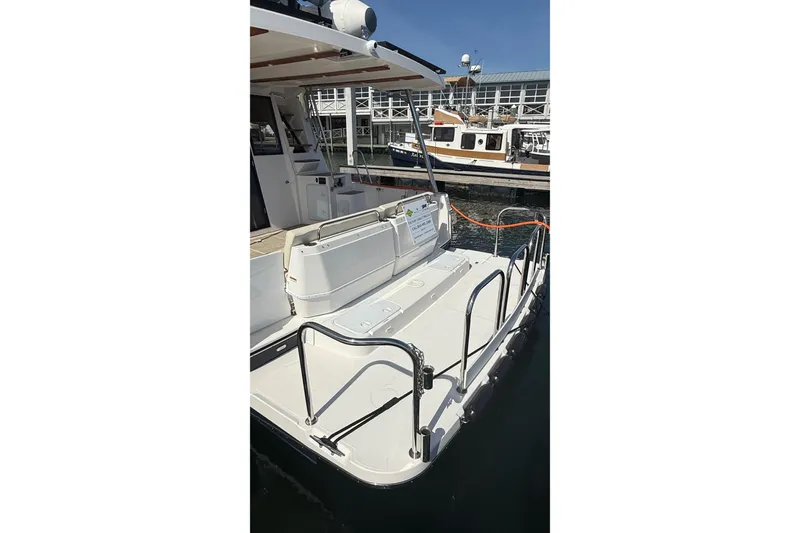 Slide: The Image of 2026 Ranger Tugs R-43 CB boat stern view at marina, showcasing deck and railing. - 5