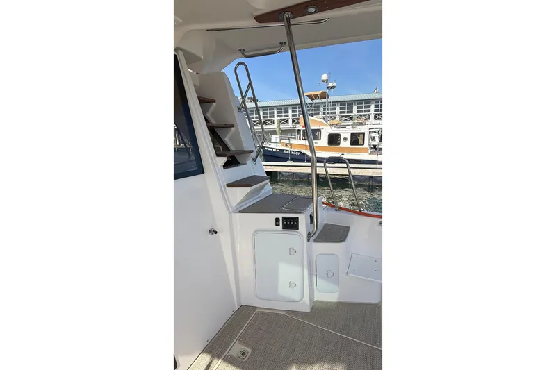 Slide: The Image of Interior view of 2026 Ranger Tugs R-43 CB boat with stairs and dock background. - 9