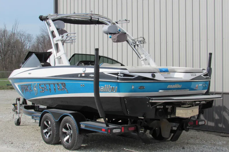 Slide: The Image of 2013 Malibu Wakesetter 20 VTX boat on trailer, parked outdoors. - 2