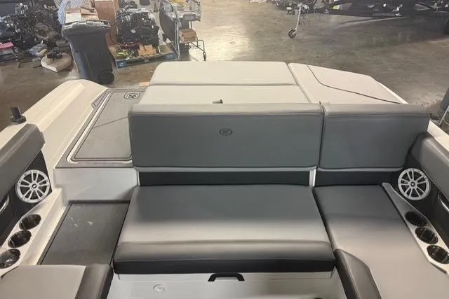 Slide: The Image of 2025 Cobalt CS22 boat interior with gray seating and cup holders in a showroom. - 16