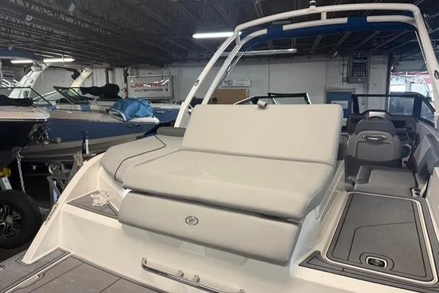 Slide: The Image of 2025 Cobalt CS22 boat interior with cushioned seating in a showroom. - 18