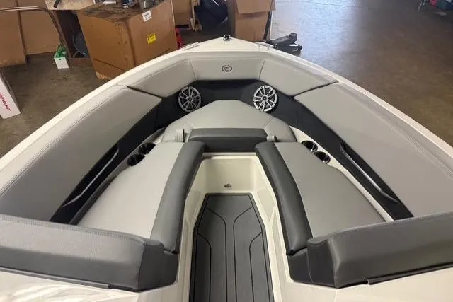 Slide: The Image of 2025 Cobalt CS22 boat interior with gray seating and speakers in a showroom. - 4