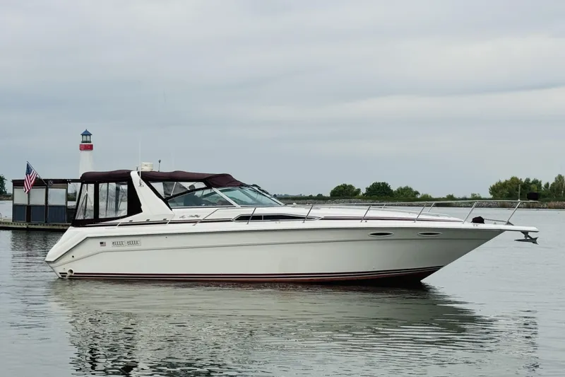 The Image of 1991 Sea Ray Sundancer 350 yacht on calm water near a lighthouse. - 1