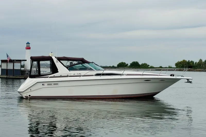 Slide: The Image of 1991 Sea Ray Sundancer 350 yacht on calm water near a lighthouse. - 10