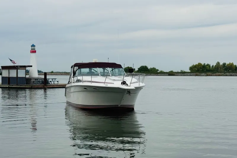 Slide: The Image of 1991 Sea Ray Sundancer 350 yacht near a lighthouse on calm waters. - 12