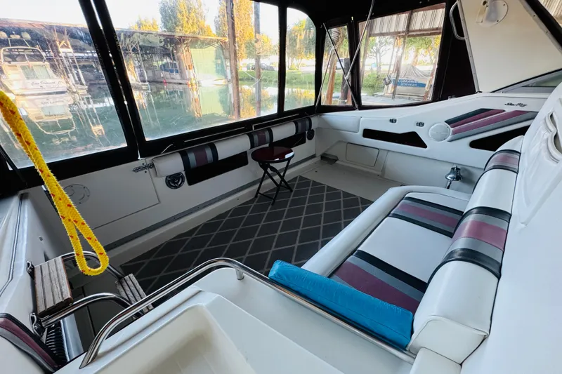 Slide: The Image of Interior of 1991 Sea Ray Sundancer 350 boat with striped seating and large windows. - 26