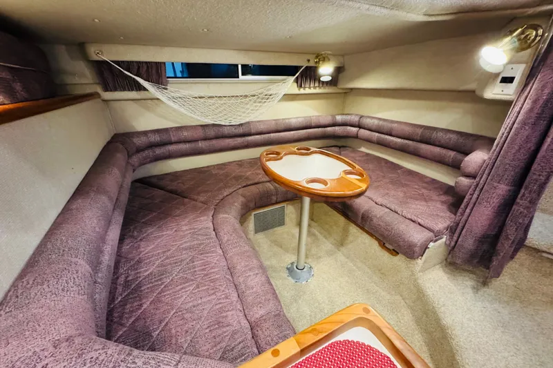 Slide: The Image of Interior of a 1991 Sea Ray Sundancer 350 with plush seating and a wooden table. - 31