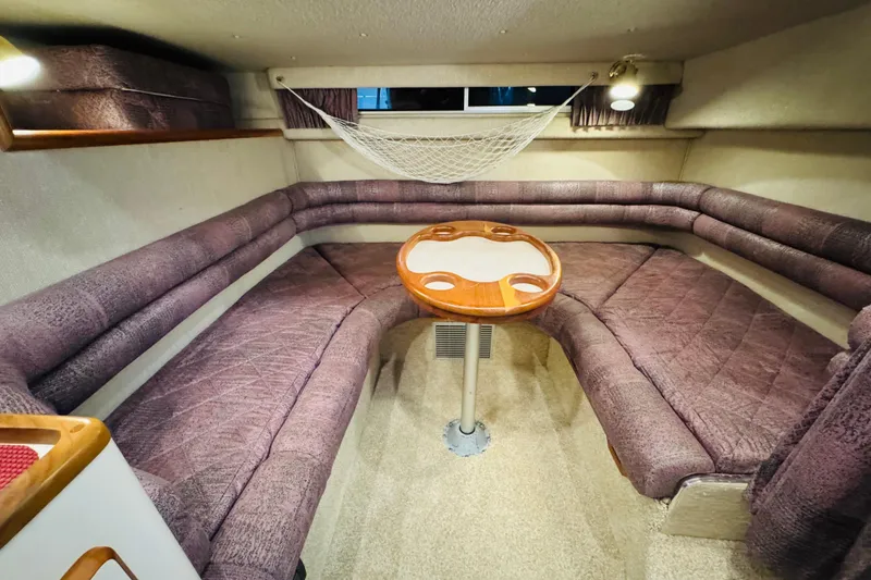 Slide: The Image of 1991 Sea Ray Sundancer 350 cabin interior with purple seating and wooden table. - 32