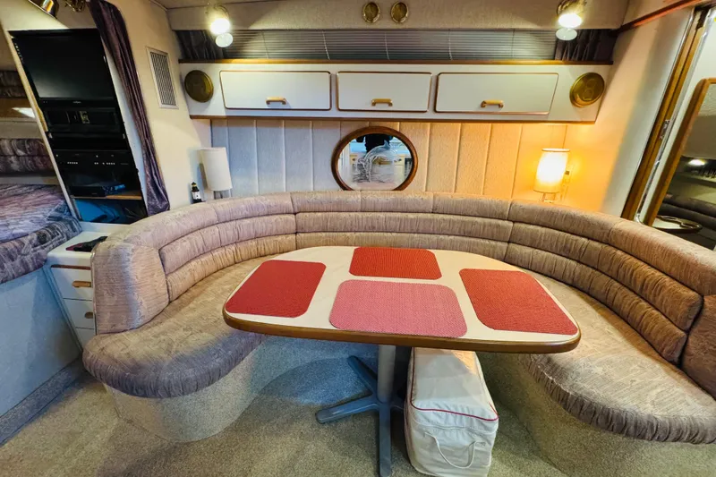 Slide: The Image of 1991 Sea Ray Sundancer 350 interior with curved seating and dining table. - 33