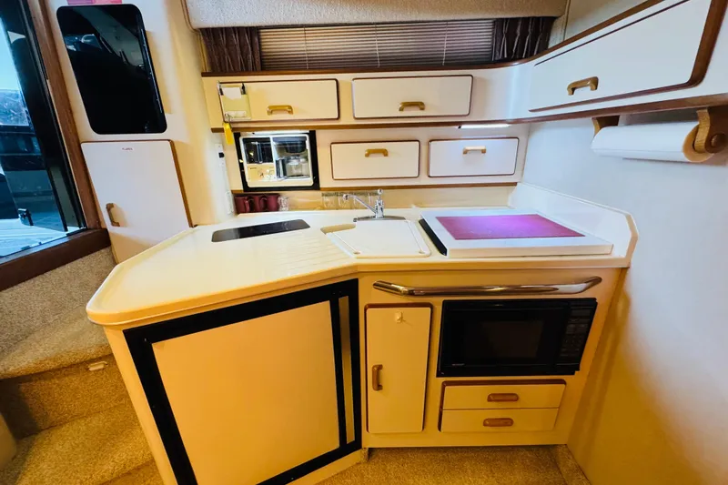 Slide: The Image of 1991 Sea Ray Sundancer 350 yacht kitchen with modern appliances and ample storage. - 34