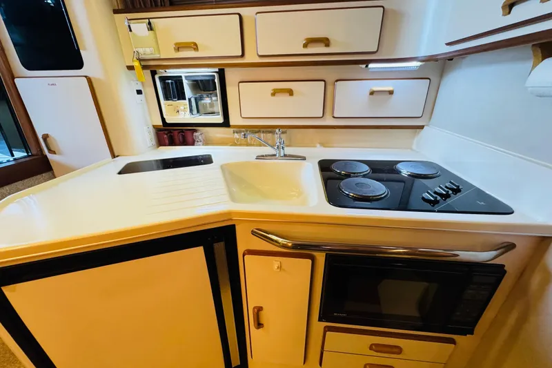 Slide: The Image of Compact kitchen in a 1991 Sea Ray Sundancer 350 yacht with stove, sink, and microwave. - 35