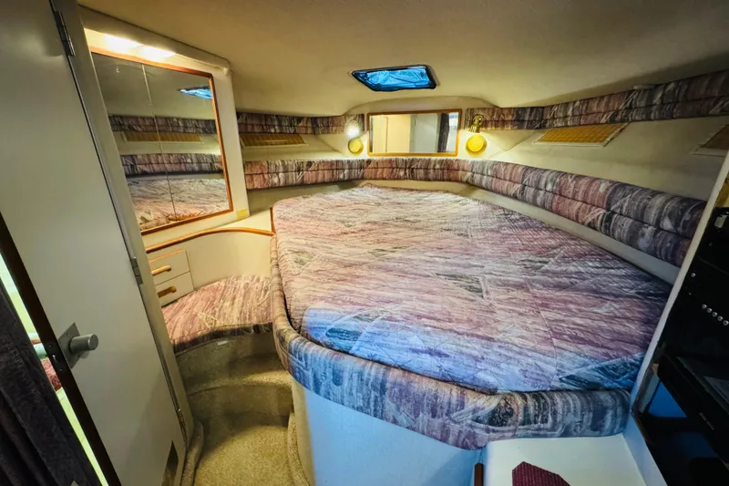 Slide: The Image of Cozy cabin interior of 1991 Sea Ray Sundancer 350 with patterned bedding and ambient lighting. - 36