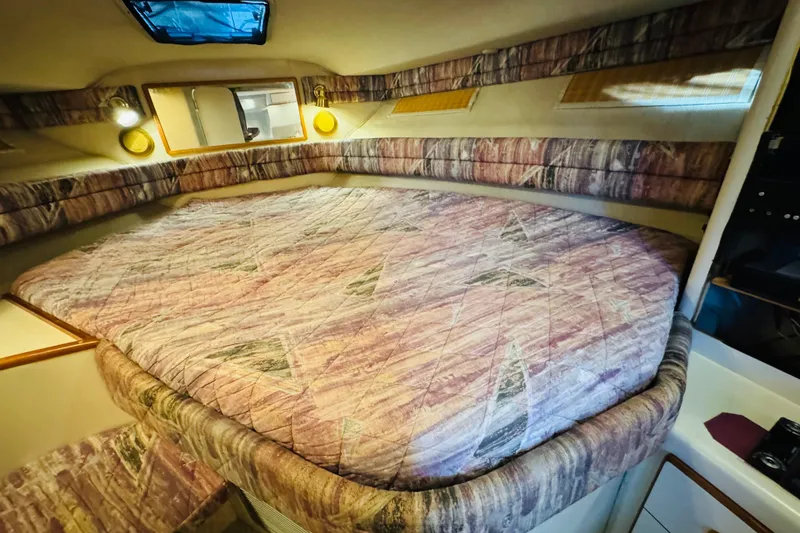 Slide: The Image of Interior cabin of a 1991 Sea Ray Sundancer 350 with patterned bedding and cozy lighting. - 37