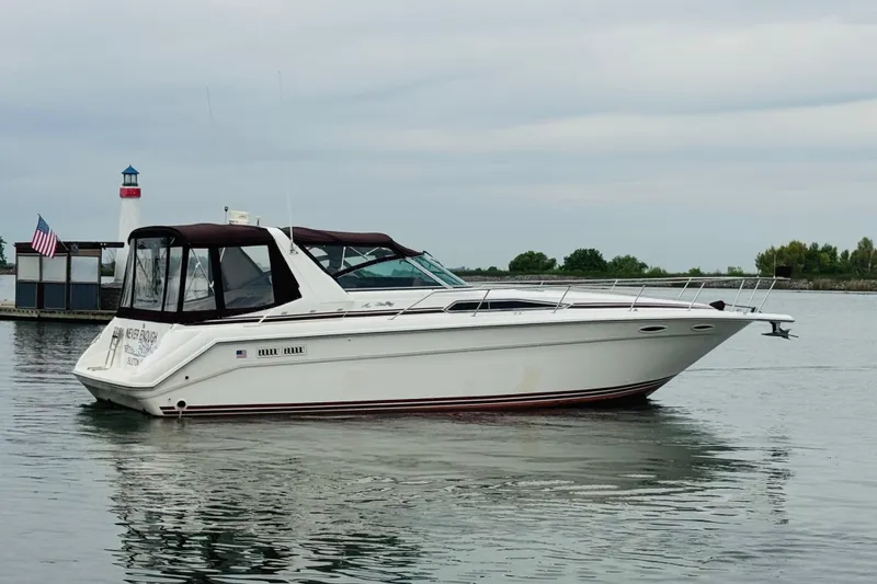 Slide: The Image of 1991 Sea Ray Sundancer 350 yacht on calm water near a lighthouse. - 9