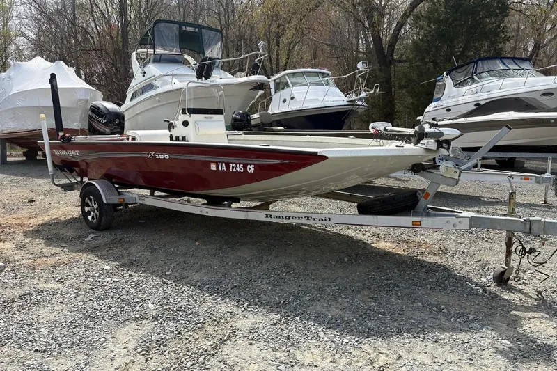 Slide: The Image of 2016 Ranger RB190 boat on trailer, parked among other boats in a gravel lot. - 2