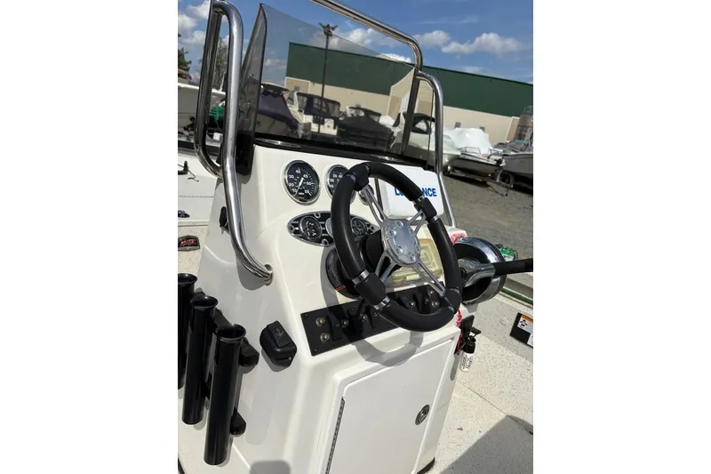 Slide: The Image of 2016 Ranger RB190 boat console with steering wheel and gauges under a clear sky. - 5