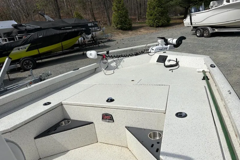 Slide: The Image of 2016 Ranger RB190 boat deck with fishing equipment, parked near other boats. - 8