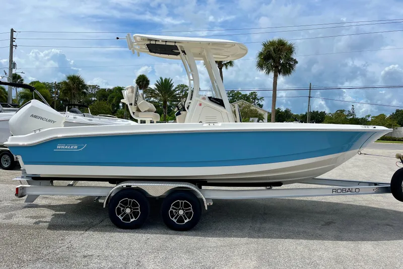 The Image of 2026 Boston Whaler 220 Dauntless on trailer, blue and white design. - 1