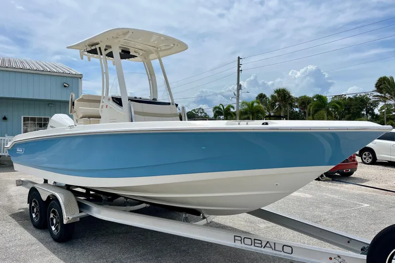 Slide: The Image of 2026 Boston Whaler 220 Dauntless boat on trailer, blue and white design. - 2