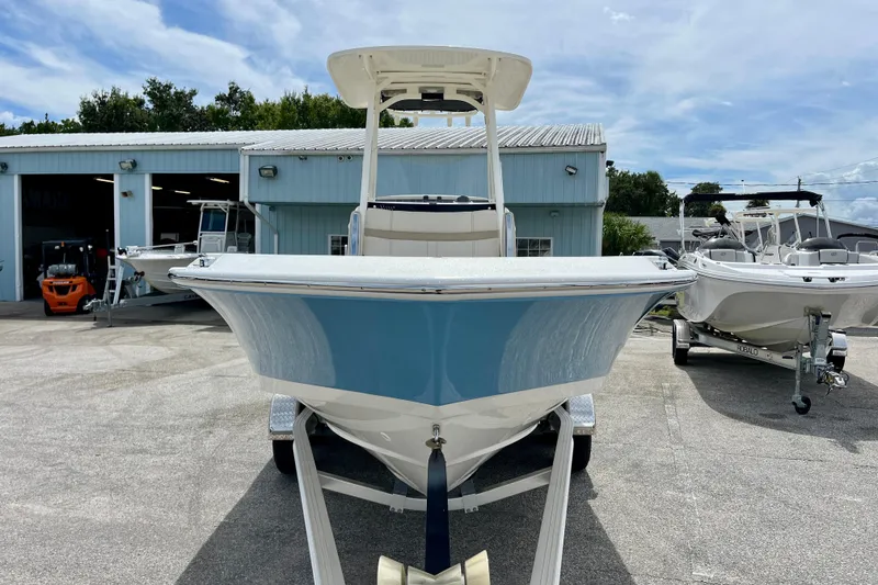 Slide: The Image of 2026 Boston Whaler 220 Dauntless boat on trailer outside warehouse. - 3