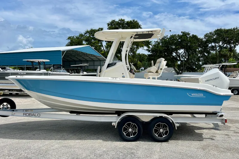 Slide: The Image of 2026 Boston Whaler 220 Dauntless on trailer, blue and white design. - 5