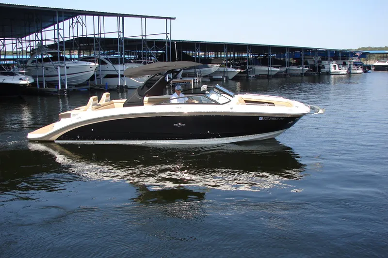 Slide: The Image of 2018 Sea Ray SDX 290 boat cruising near marina docks. - 1