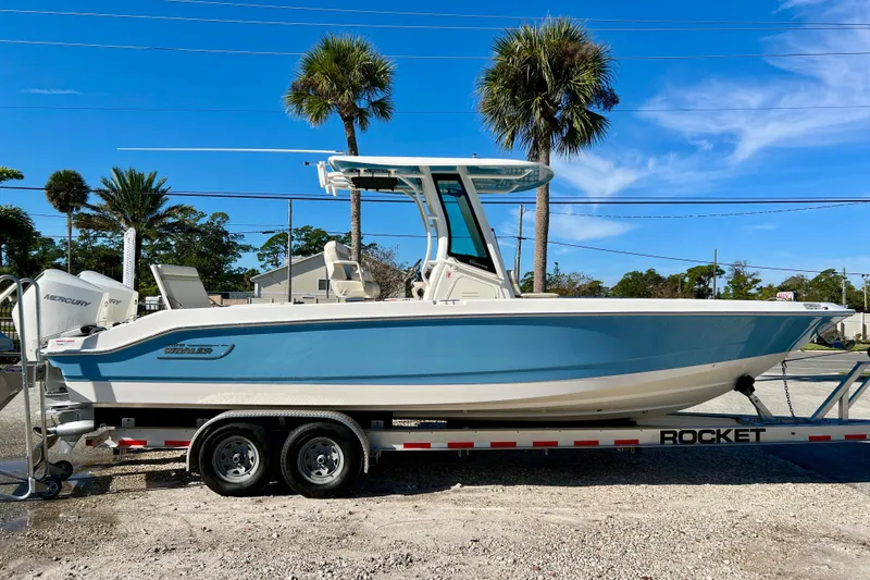 The Image of 2026 Boston Whaler 280 Dauntless on trailer, blue sky, palm trees. - 1