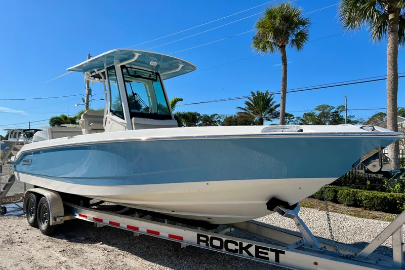 Slide: The Image of Boston Whaler 280 Dauntless 2026 on trailer, blue hull, sunny day. - 2
