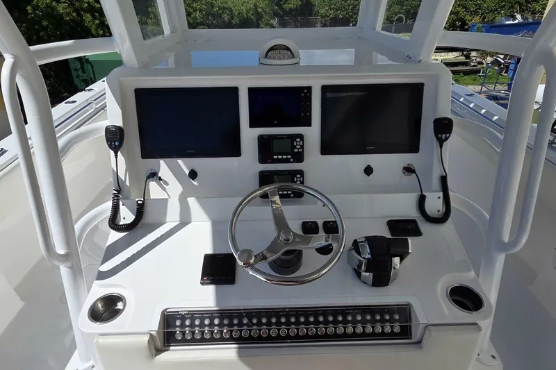 Slide: The Image of 2020 Invincible 35 Catamaran helm with dual screens, steering wheel, and controls. - 23