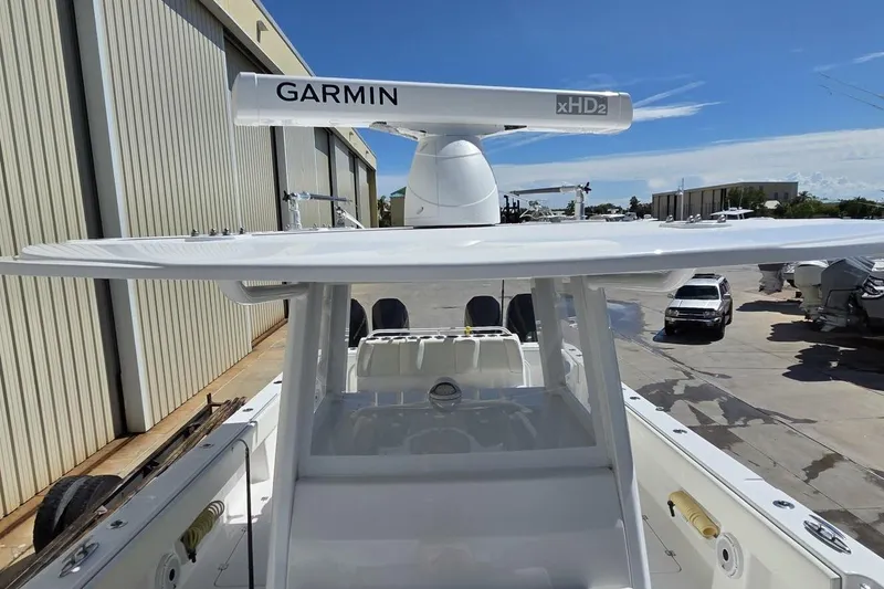 Slide: The Image of 2020 Invincible 35 Catamaran with Garmin radar, docked near industrial buildings under clear sky. - 3