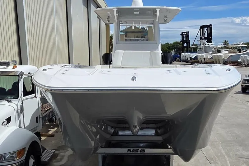 Slide: The Image of 2020 Invincible 35 Catamaran on trailer, parked outdoors near industrial buildings. - 4