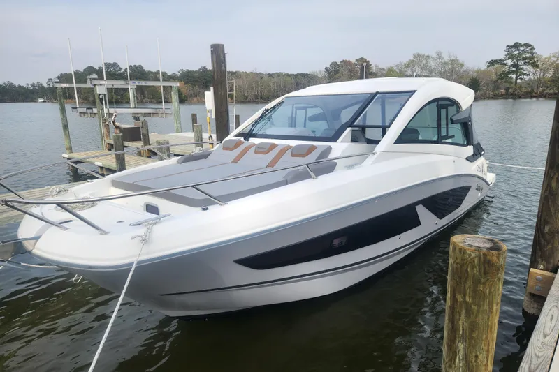 The Image of 2025 Beneteau Gran Turismo 32 yacht docked on a serene lake. - 0