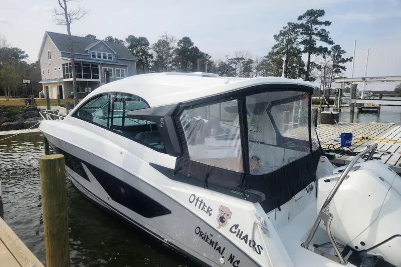 Slide: The Image of 2025 Beneteau Gran Turismo 32 docked near waterfront home, showcasing sleek design. - 1