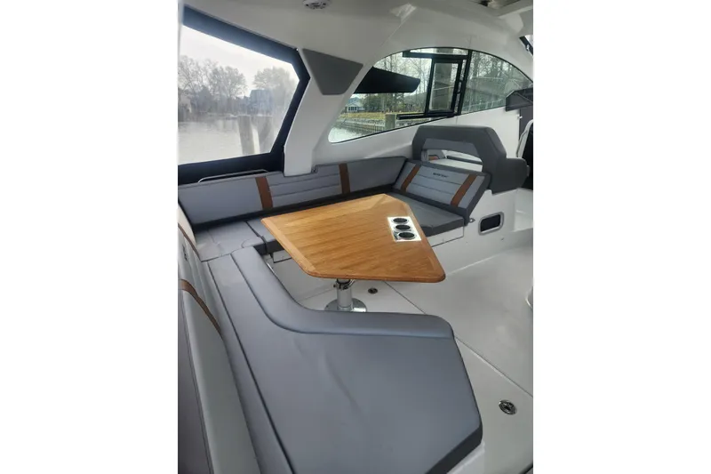 Slide: The Image of 2025 Beneteau Gran Turismo 32 interior with sleek seating and wooden table. - 10