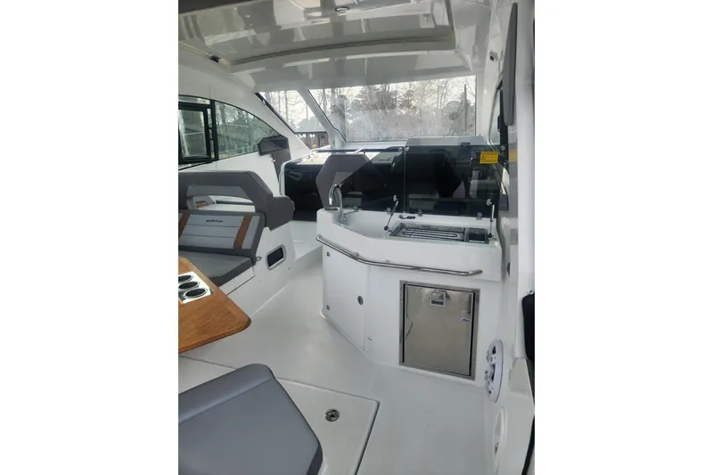 Slide: The Image of Interior of 2025 Beneteau Gran Turismo 32 yacht, featuring modern seating and kitchenette. - 11