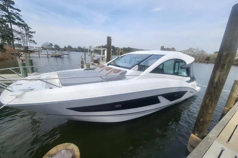 Slide: The Image of 2025 Beneteau Gran Turismo 32 yacht docked in a serene marina setting. - 2