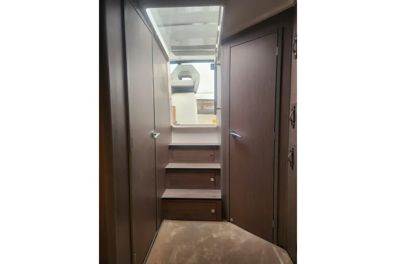 Slide: The Image of Interior view of 2025 Beneteau Gran Turismo 32 yacht, featuring wooden stairs and doors. - 29