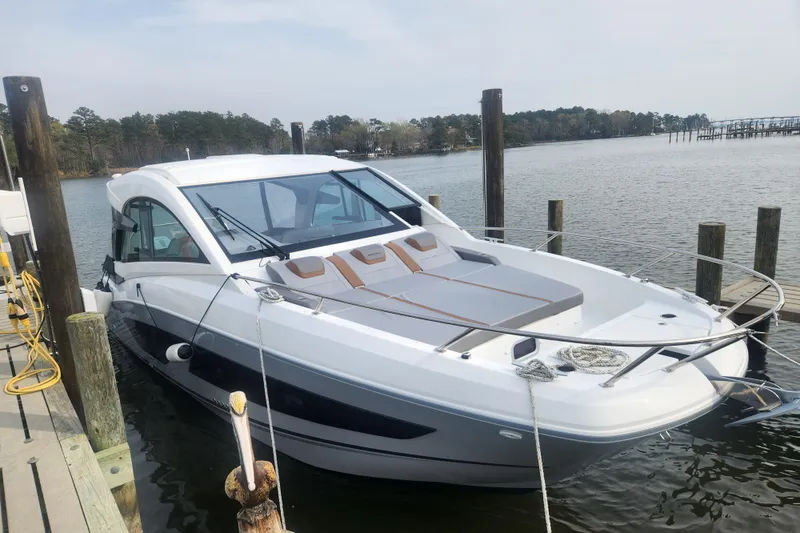 Slide: The Image of 2025 Beneteau Gran Turismo 32 yacht docked by a serene waterfront. - 3