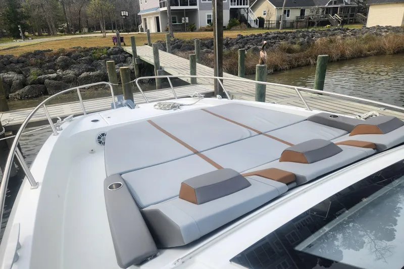 Slide: The Image of 2025 Beneteau Gran Turismo 32 yacht with spacious sunbathing area docked by a serene waterfront. - 7