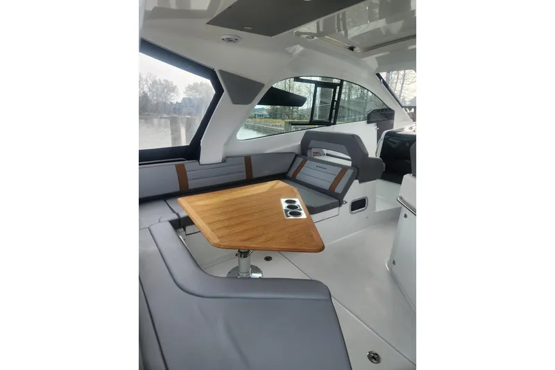 Slide: The Image of Interior of 2025 Beneteau Gran Turismo 32 yacht with sleek seating and wooden table. - 8