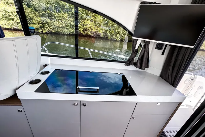 Slide: The Image of Modern kitchen area on 2023 Beneteau Antares 11 boat with sleek countertop and window view. - 18